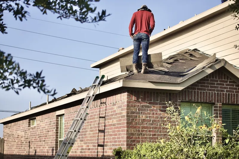 Professional roofer working on a residential roof in Rumford